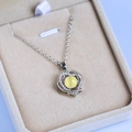 Detalle del collar de corazón plateado con piedra lunar amarilla y circón en un joyero elegante - Amarillo