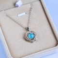 Macro shot of silver heart pendant with blue moonstone and pavé crystals in a beige box - Aqua