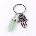 Detail of silver Hamsa hand charm and light green hexagonal crystal pendant on keychain - Green Aventurine