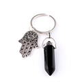 Macro detail of silver Hamsa Hand charm and black hexagonal crystal pillar on keychain - Black