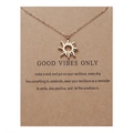 Detail van de gouden zon hanger ketting op een bruine geschenkkaart voor goede vibes - Gouden Zon Hanger Ketting (NC18Y0303)