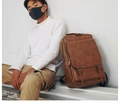 Brown PU leather backpack with vintage double buckle design shown in a lifestyle setting - Khaki (Wide Sponge Mesh Strap)