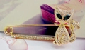 Golden cat brooch with green gem eyes and sparkling crystals on a safety pin base - Gold