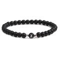 Macro shot of 6mm matte black stone beads with letter X charm and silver metal accents - Letter X