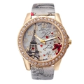 Close-up of rhinestone gold bezel watch featuring Eiffel Tower and Love floral dial - Gray
