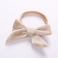 Detailed view of beige velvet baby headband with soft nylon bow on white background - Off White