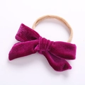 Detail of purple velvet bow attached to a beige elastic nylon headband for babies - Fuschia