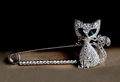 Silver cat brooch with green gem eyes and sparkling crystals on a dark background - Silver