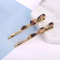 Detail of retro oval leopard resin hair clips with bronze metal base on marble background - Wave Antique Gold