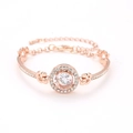 Dettaglio macro del bracciale in oro rosa con zircone centrale e incastonatura pavé - Oro rosa