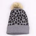 Detail of grey leopard print knit beanie with fluffy faux fur pompom and ribbed cuff - Light Gray