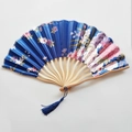 Detailed macro of a blue Japanese silk folding fan with floral patterns and bamboo ribs - NO7 Royal Blue