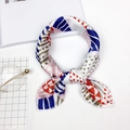 Elegant silk scarf with colorful geometric patterns shown on white tabletop decor - Colorful Geometric