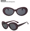 Detail view of oval plum red sunglasses featuring a wide frame and dark gray lenses - Burgundy Frame Grey Lens