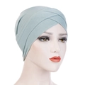 Detail of mint green elastic turban hat with pleated cross design on a model head - Mint Green