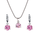 Primer plano de un juego de joyas de plata con colgantes redondos de circón rosa sobre blanco - Rosa