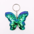 Porte-clés papillon en paillettes vertes et bleues avec anneau sur fond blanc neutre - Anneaux de Jonction Argentés / Vert iridescent