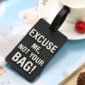 Black PVC luggage tag with white EXCUSE ME NOT YOUR BAG text on a magazine background - Black