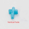 Detail of blue synthetic opal cross bead with visible vertical hole and fire luster - Blue No.5 - Vertical Hole