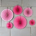 Set of 6 pink decorative paper fans with stripes and dots hanging on a stone wall - Rose Red Striped