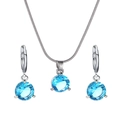 Vue détaillée du collier et des boucles d'oreilles en argent sertis de zircons bleus - Rose bonbon