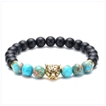 Macro detail of leopard head charm on black matte and turquoise stone beaded bracelet - Leopard - Antique Gold