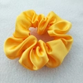 Detail shot of a yellow satin scrunchie showing soft pleats and smooth fabric texture - Lemon Yellow