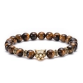 Macro shot of tiger eye stone beads with a golden leopard head charm on an elastic bracelet - Leopard Head / Antique Gold