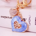Elegante llavero dorado con un colgante de corazón en esmalte azul y un corazón de pedrería - Azul