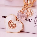 Llavero de corazón dorado con dije de esmalte blanco y colgante de pedrería brillante - Blanco