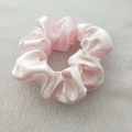 Detail of pink satin scrunchie showing glossy silk texture and pleated elastic design - Flesh Pink