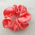 Close-up of pink satin silk scrunchie with elegant pleated texture on a soft background - Sweet Pink