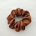Lustrous brown satin scrunchie with smooth silk texture on white fabric background - Bronze