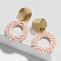 Detail of pink crystal bead earrings with gold metal discs on a white geometric stand - erp46 Pink