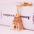 Porte-clés Tour Eiffel doré orné de strass ambrés sur fond artistique - Pêche