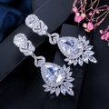 Macro detail of silver teardrop earrings with AAA cubic zirconia in luxury lighting - White