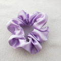 Detailed view of a purple satin scrunchie showing glossy fabric texture and soft pleats - Deep purple