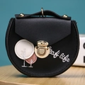 Detail of a black PU leather round coin purse with leaf life embroidery and gold clasp - Black