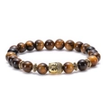 Macro view of Tiger Eye stone beads and a detailed golden Buddha head charm on the bracelet - Buddha Head / Antique Gold