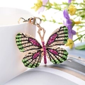 Elegant gold-tone butterfly keychain with colorful green and pink crystals for bags - Fuschia