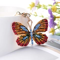 Portachiavi a farfalla dorata con strass colorati appeso a una tazza di ceramica - Rosso