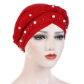 Close-up of red turban cap with braided detail, white pearls, and silver beads - Red