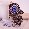 Hamsa-Hand-Schlüsselanhänger mit bösem Blick Anhänger und Goldmuster an weißer Tasse - Schwarz