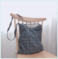 Minimalist blue and white plaid canvas tote bag hanging on a chair in a bright room - Black Grid - Single Strap (Crossbody/Shoulder)