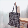 Detailed texture of black and white plaid canvas tote bag hanging on wooden chair - Black Grid - Double Straps (Handheld/Shoulder)