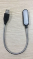 Dettaglio macro della lampada LED USB nera portatile con collo di cigno flessibile su legno - Nero