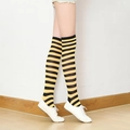 Knee-high socks in yellow and black stripes with white sneakers on a model - Yellow Plaid