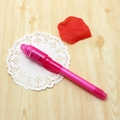Penna magica rosa a luce UV invisibile su uno sfondo decorativo in pizzo - Rosa