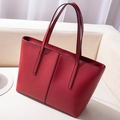 Elegant red oversized tote bag in matte leather finish on a white sofa setting - Red
