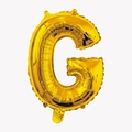Macro shot of 32 inch golden foil balloon shaped like the letter G for party decor - Letter G